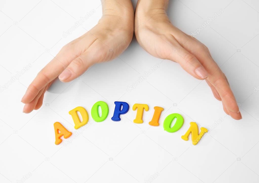 Female hands and word ADOPTION