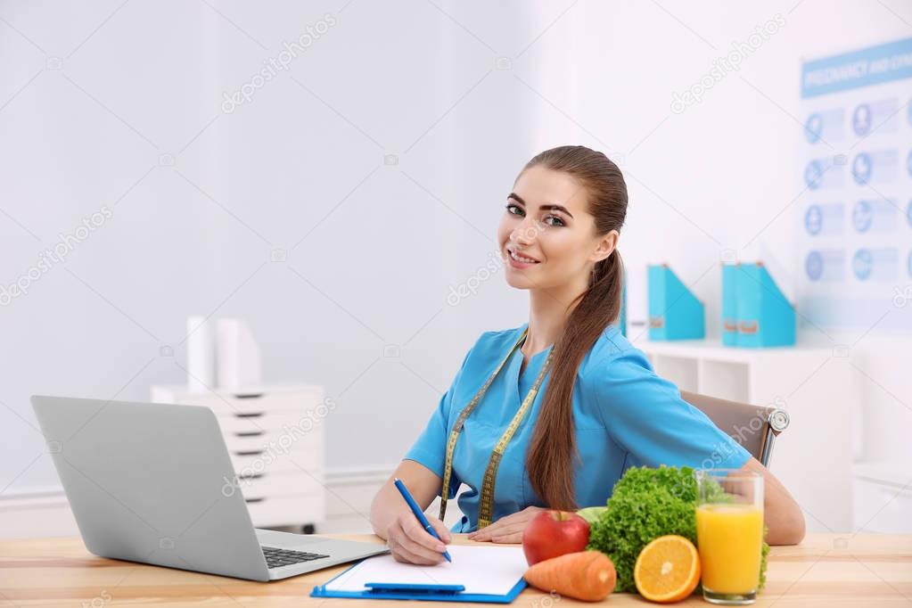 Young female nutritionist in her office