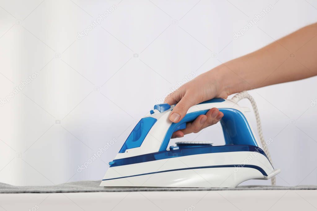 Female hand ironing clothes 