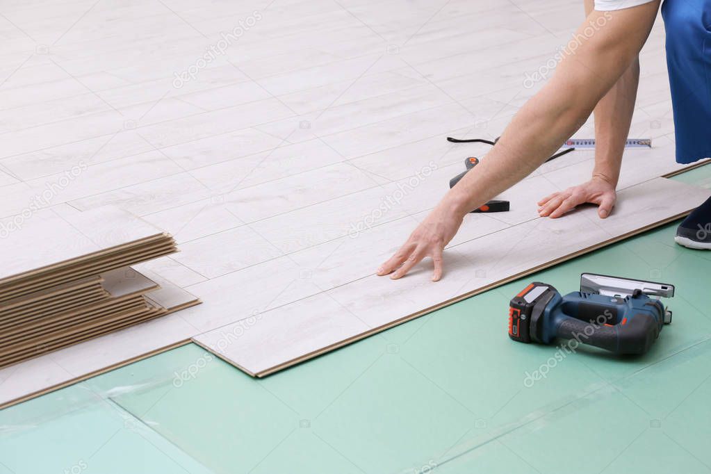Man installing new wooden laminate flooring