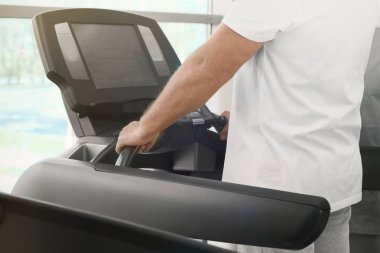 Koşu bandı üzerinde olgun adam