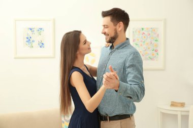 Genç çift odada dans ediyor.