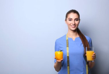 Açık renk arka plan üzerinde genç kadın beslenme uzmanı