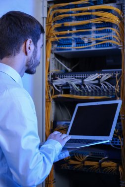 Sunucu odası içinde laptop ile yakışıklı genç mühendis