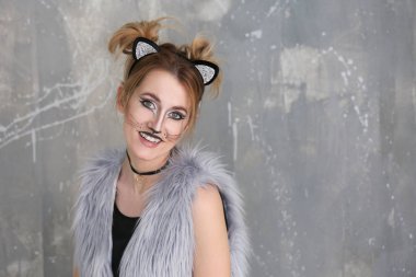 Kedi makyaj ve grunge arka plan kulaklara olan güzel kadın