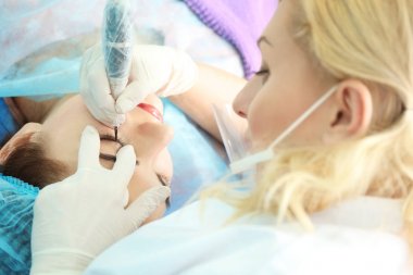 Genç güzel kadın kozmetik salonda kalıcı makyaj yapma