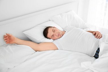 Evde yatakta uyuyan genç çekici adam