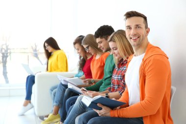 Grup kitap ve ışık duvara yakın oturan becerikli alet ile insan