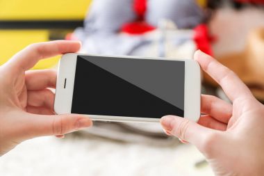 Eller genç kadın ile cep telefonu arka plan bulanık. Seyahat uygulamaları kavramı