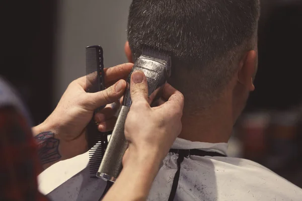 Barber making modern male hairstyle