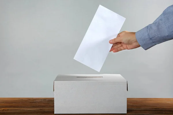 Male hand putting voting ballot — Stock Photo, Image