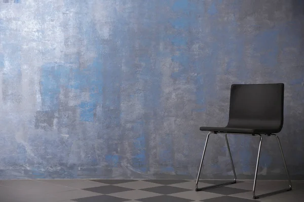Židle u šedé stěny — Stock fotografie
