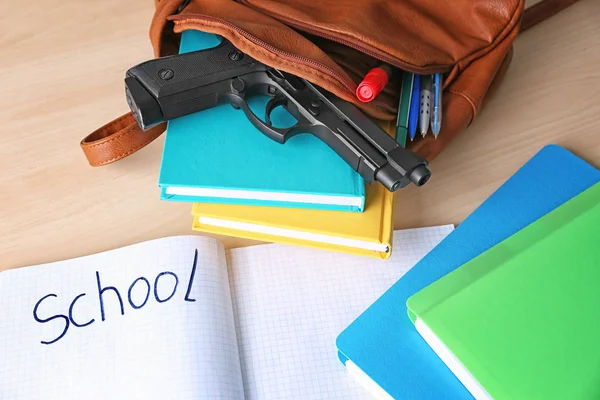 Školní batoh s knihami, šablony a pistoli na stůl — Stock fotografie