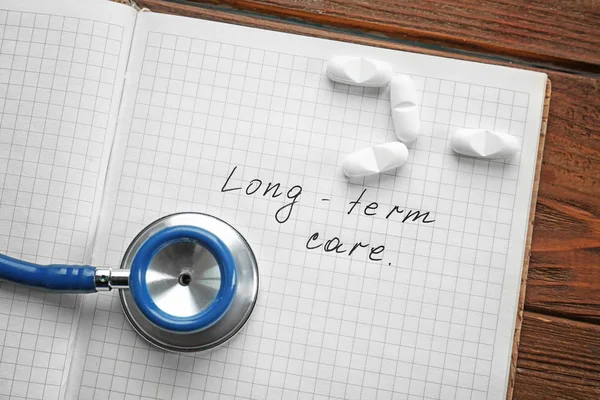 Stethoscope and notebook with text LONG-TERM CARE