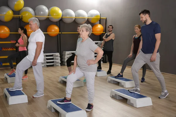 People of different ages training in gym