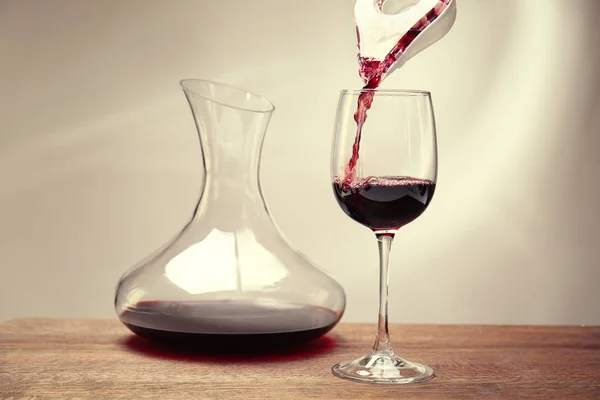 Наливание вина в бокал на стол — стоковое фото