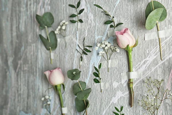 Hermosas flores pegadas a la pared de color — Foto de Stock