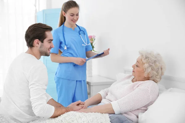 Giovane uomo che parla con nonna e infermiera — Foto Stock