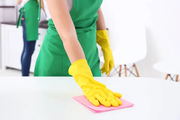 Young woman cleaning office table