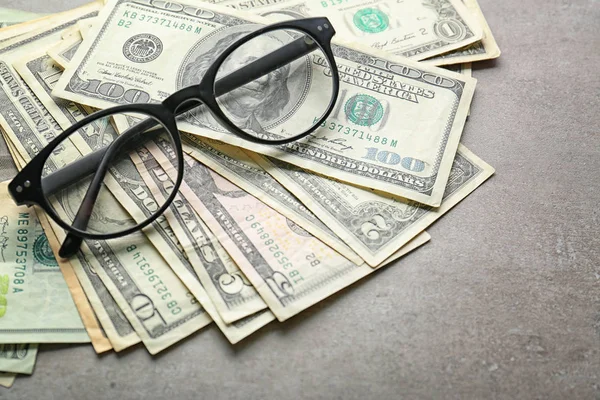 แว่นตาและดอลลาร์บนโต๊ะ — ภาพถ่ายสต็อก