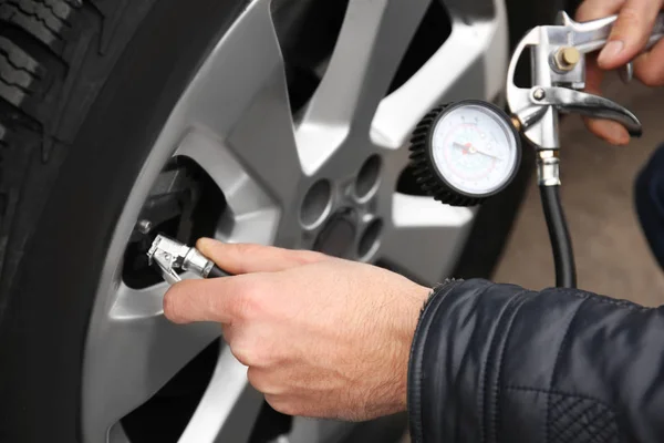 Auto mechanic checking tire pressure — Stock Photo, Image