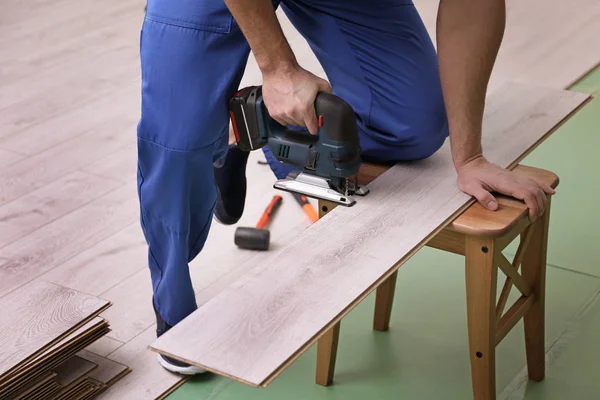 Man cutting laminate board with jigsaw — Stock Photo, Image