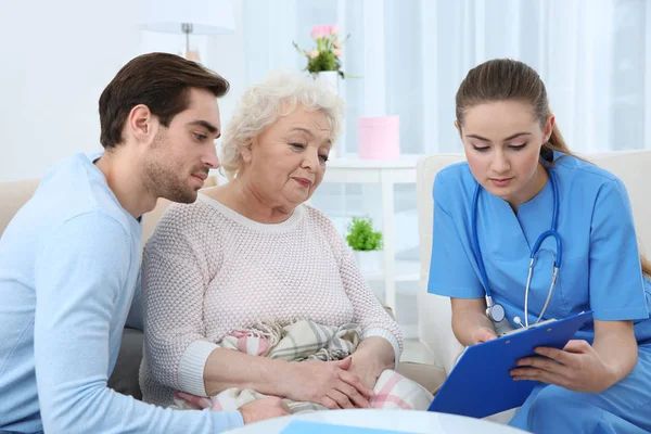 护士谈话与祖母和她的孙子在室内 — 图库照片