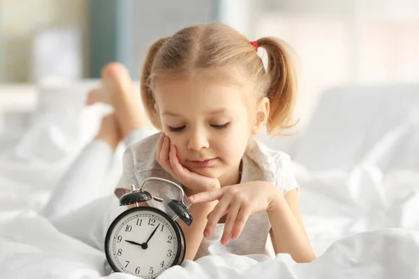 Маленькая девочка с будильником — стоковое фото