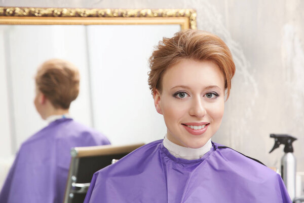 Young woman with trendy hairstyle at beauty salon