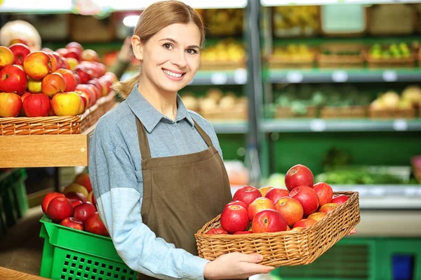 Schöne Verkäuferin mit Früchten — Stockfoto