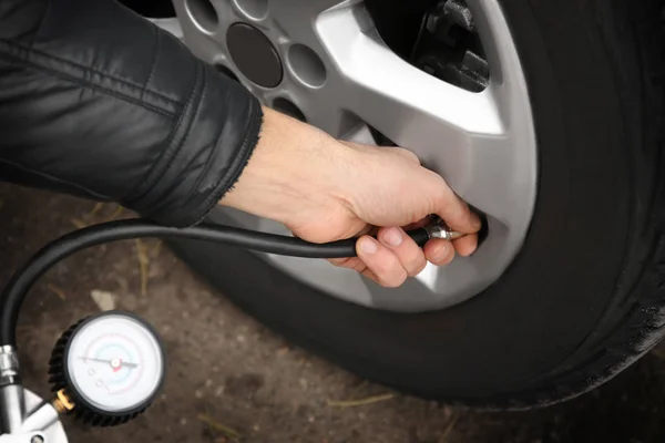 Auto mechanic checking tire pressure — Stock Photo, Image