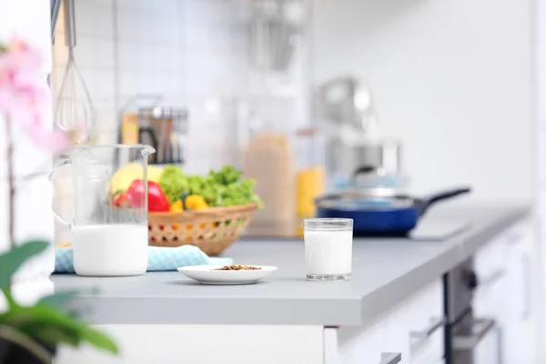 Assiette avec nourriture sèche et lait préparé pour chat sur le comptoir de la cuisine — Photo