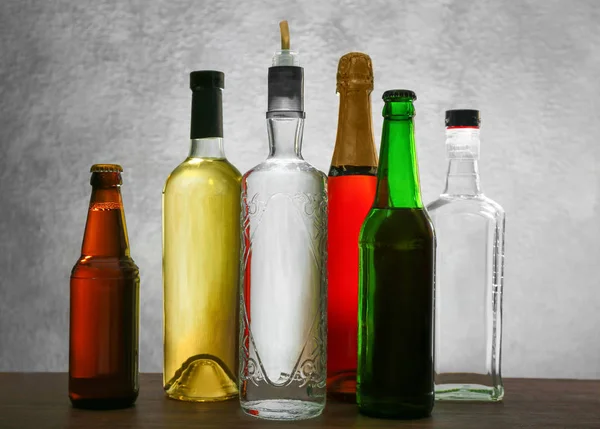 Different bottles of wine and spirits on color background — Stock Photo, Image