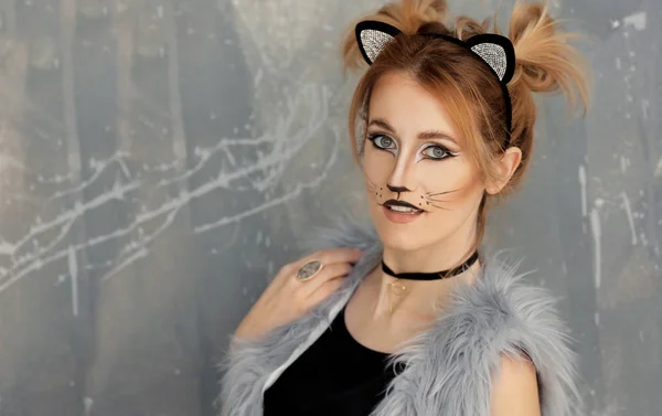 Piękna młoda kobieta kot makijaż i uszy na tło grunge — Zdjęcie stockowe