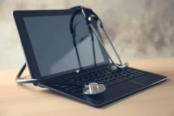 Modern laptop and stethoscope — Stock Photo, Image