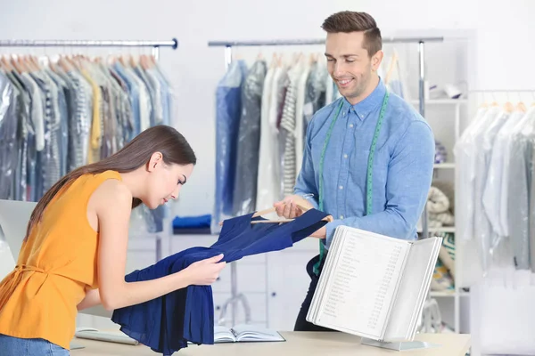 Man working with customer in dry-cleaning salon — Stock Photo, Image