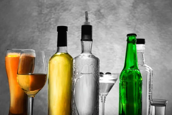 Verschillende flessen wijn en gedistilleerde dranken op kleur achtergrond — Stockfoto
