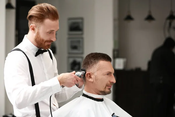 Barber making modern male hairstyle