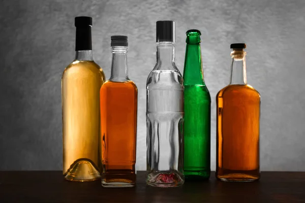 Diferentes botellas de vino y licores sobre fondo de color — Foto de Stock