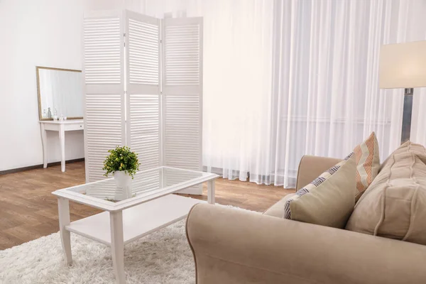 Интерьер красивой гостиной с раскладным экраном и диваном — стоковое фото