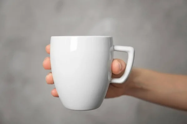 Blank white cup in hand — Stock Photo, Image