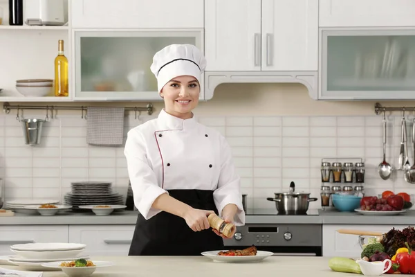 Chef mulher adicionando pimenta — Fotografia de Stock