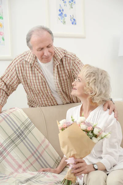 Seniorchef schenkt seiner Frau zu Hause Blumen — Stockfoto
