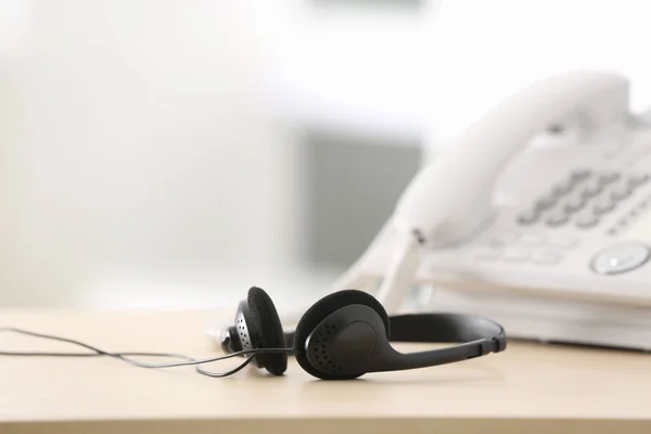 Auriculares negros en la mesa del agente de soporte técnico en la oficina —  Fotos de Stock