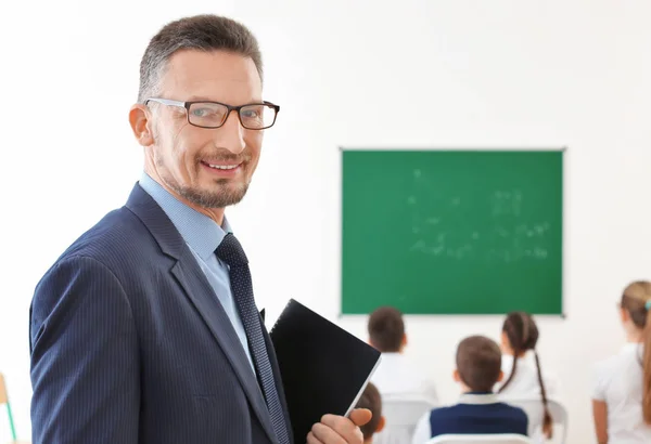 Handsome teacher with notepads in classroom — Stock Photo, Image
