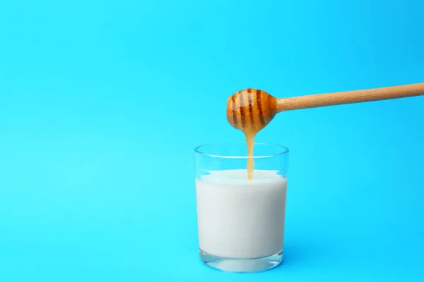 Hälla honung i glas mjölk — Stockfoto