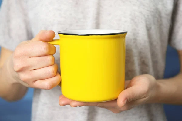 Leere gelbe Tasse in der Hand — Stockfoto