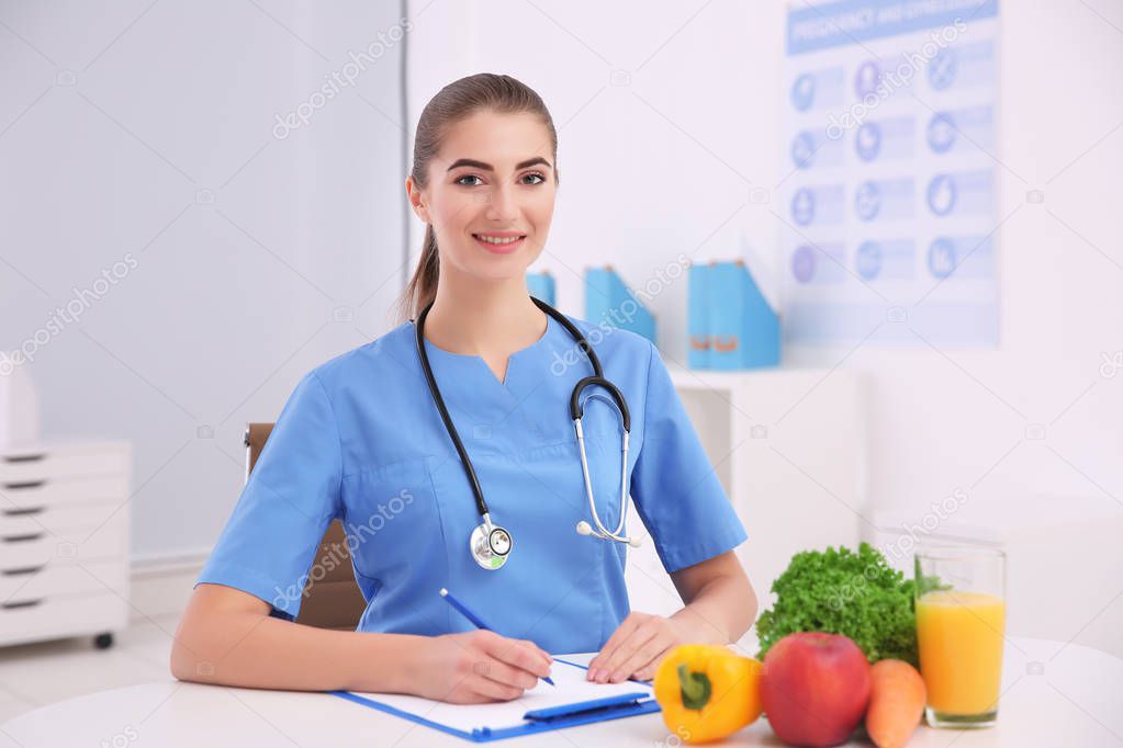 Young female nutritionist in her office