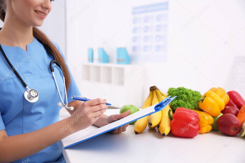 Young female nutritionist working in her office