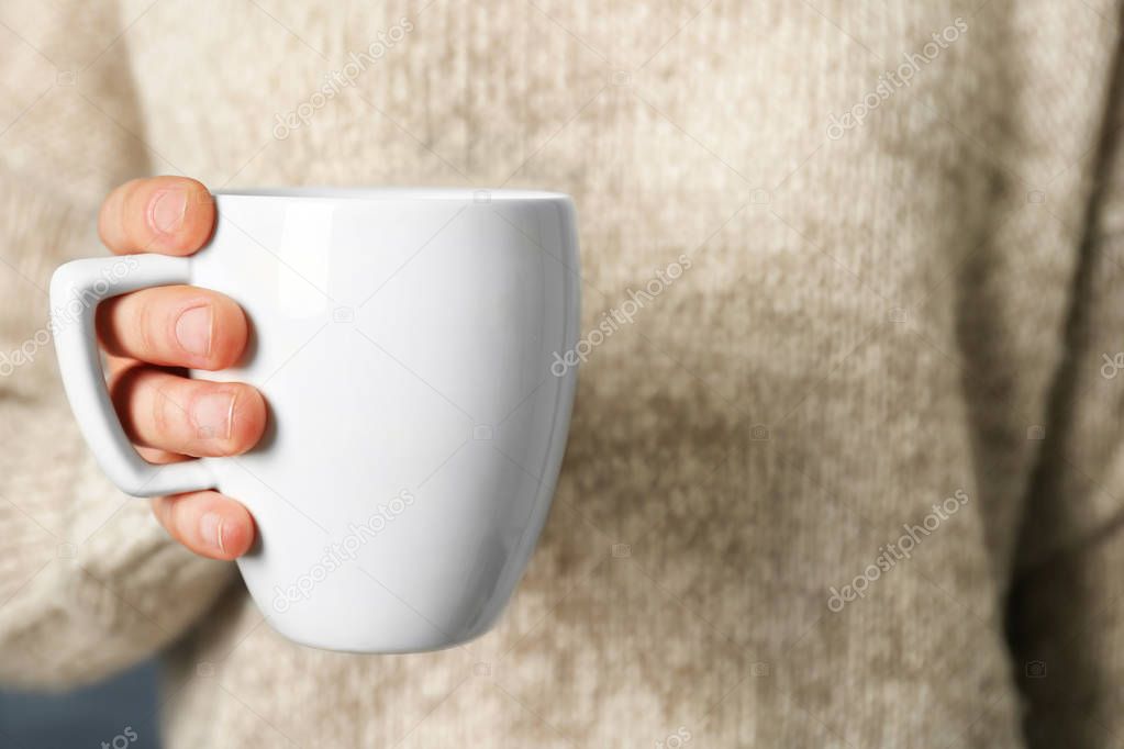 Blank white cup in hand